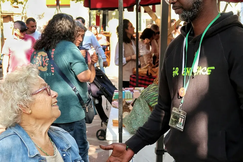 Man talking with a woman at an outdoor market