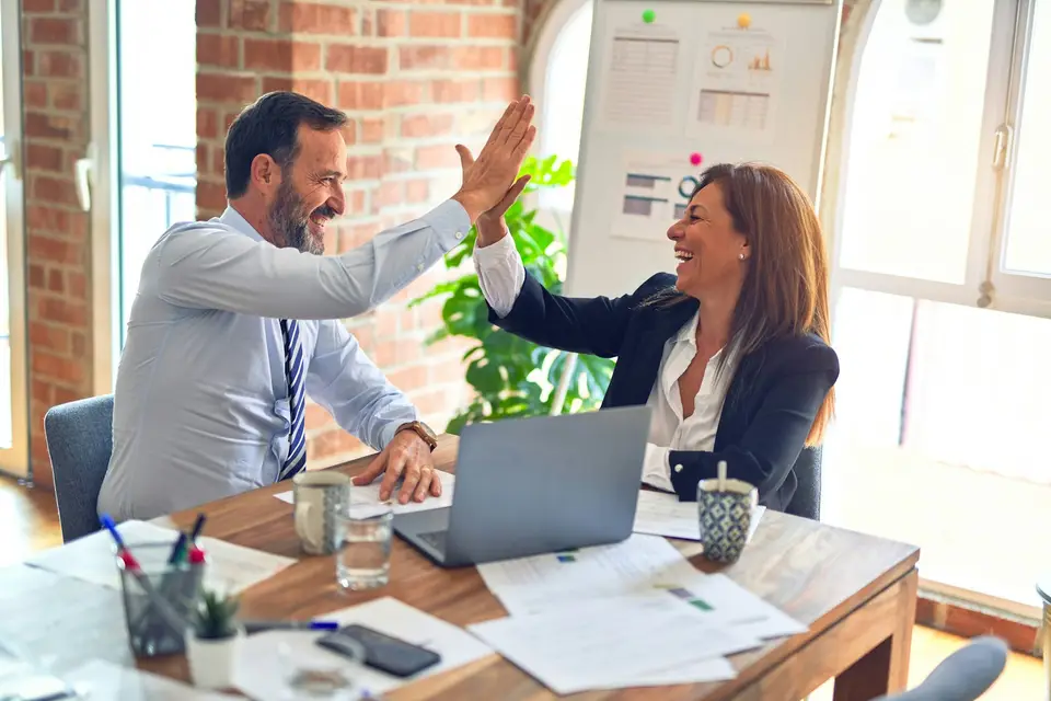 Man and woman discussing documents at a meeting table