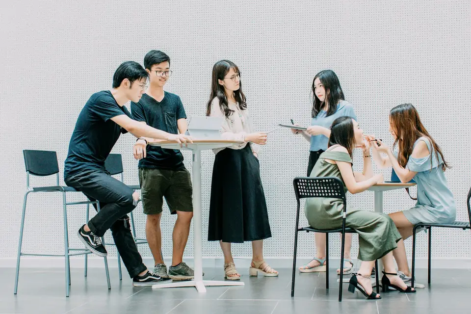 Two men and four women meeting in an office