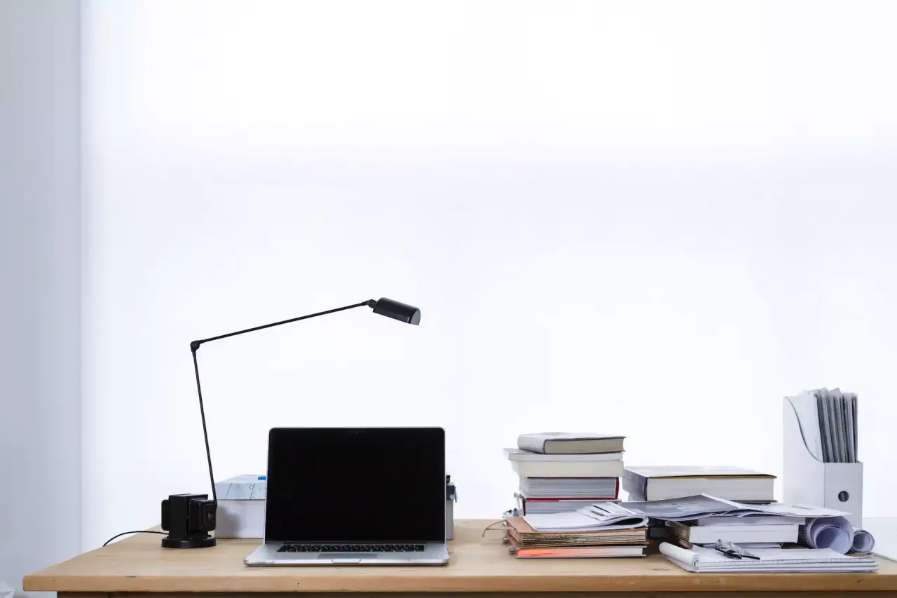 Schreibtisch mit Utensilien, Lampe Bücher Dokumente