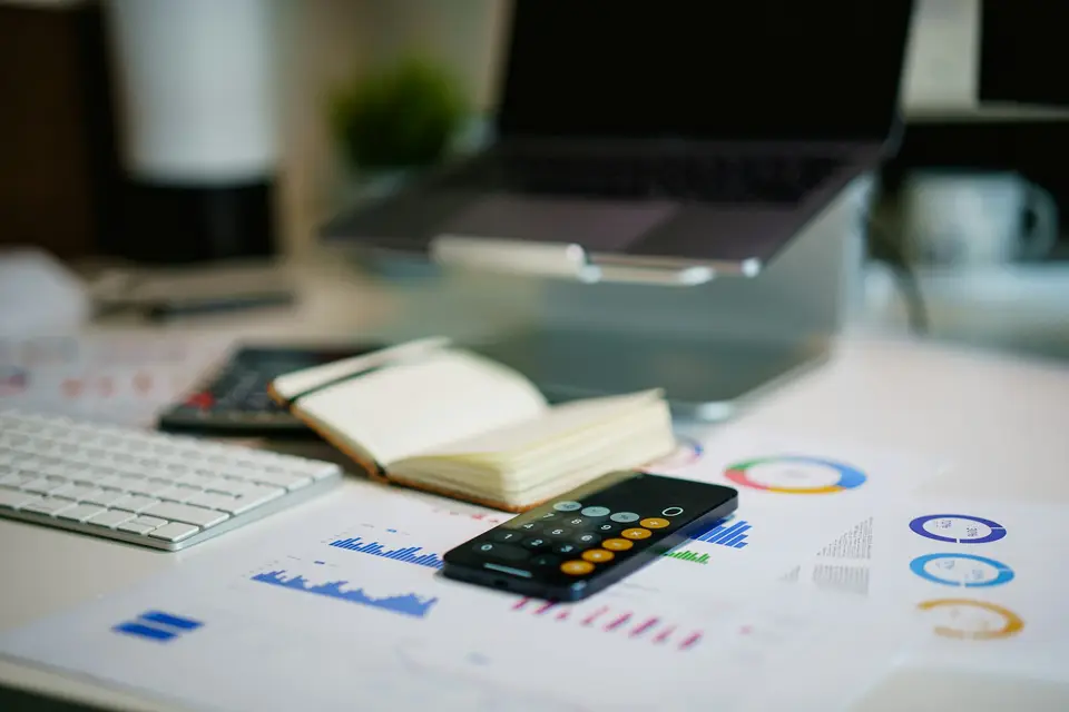 Desk with a smartphone and printed financial charts