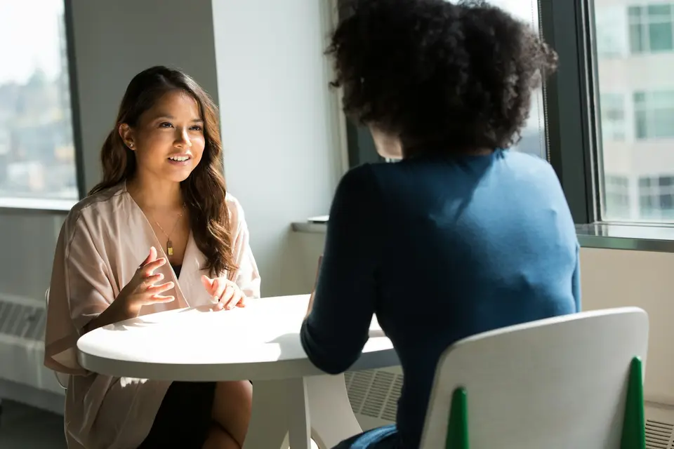 Two women in conversation sitting in chairs