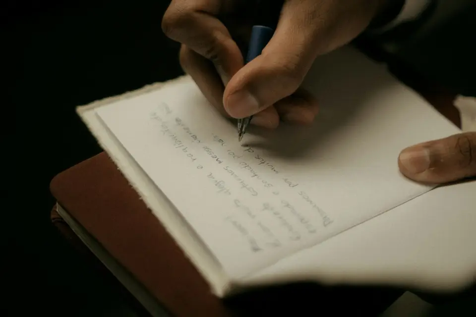 Person writing notes in a notebook