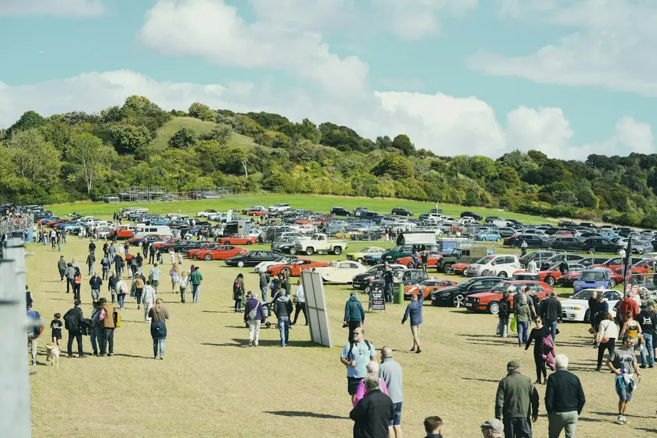 Visitors walking among vintage cars at a car show