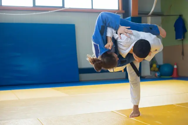 Personen im Training in der Sporthalle auf Turnmatten