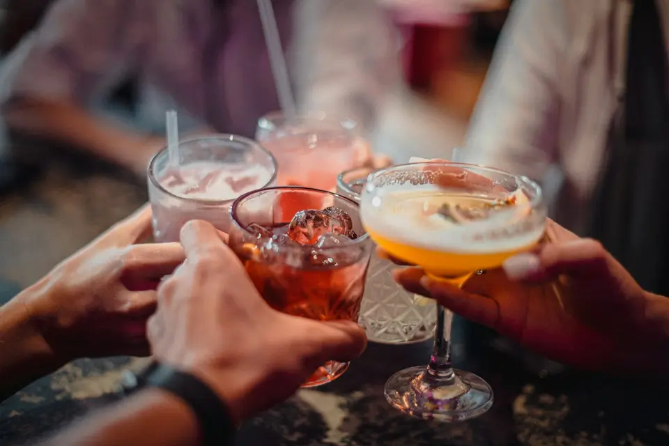 People holding drinks while talking at a reception