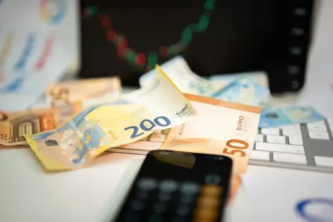 Geld und Handy liegen auf der Tastatur
