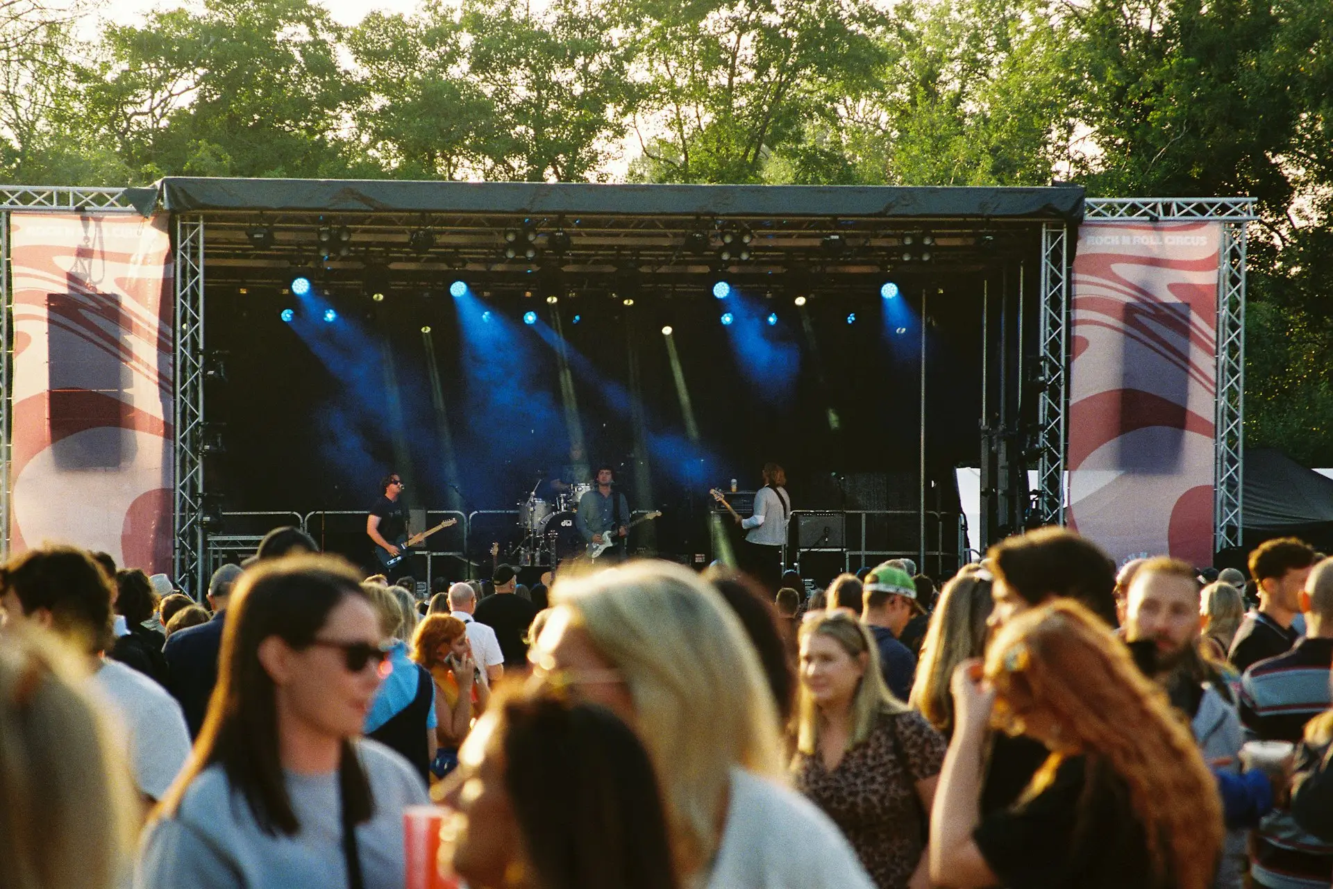 Publikum vor einer Freiluftbühne, auf der eine Band spielt