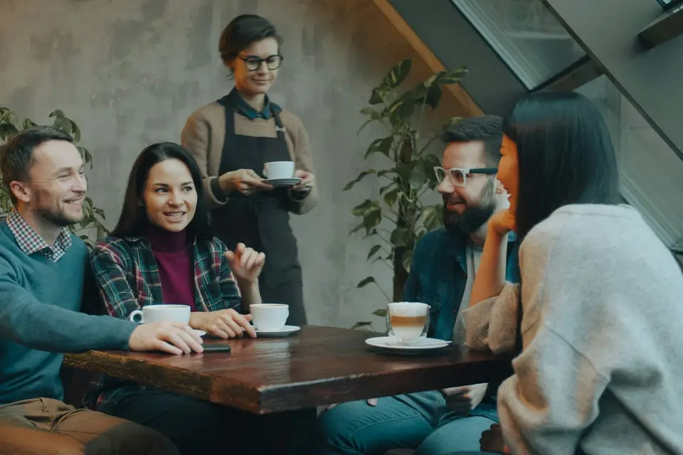 Gruppe unterhält sich an einem Cafétisch