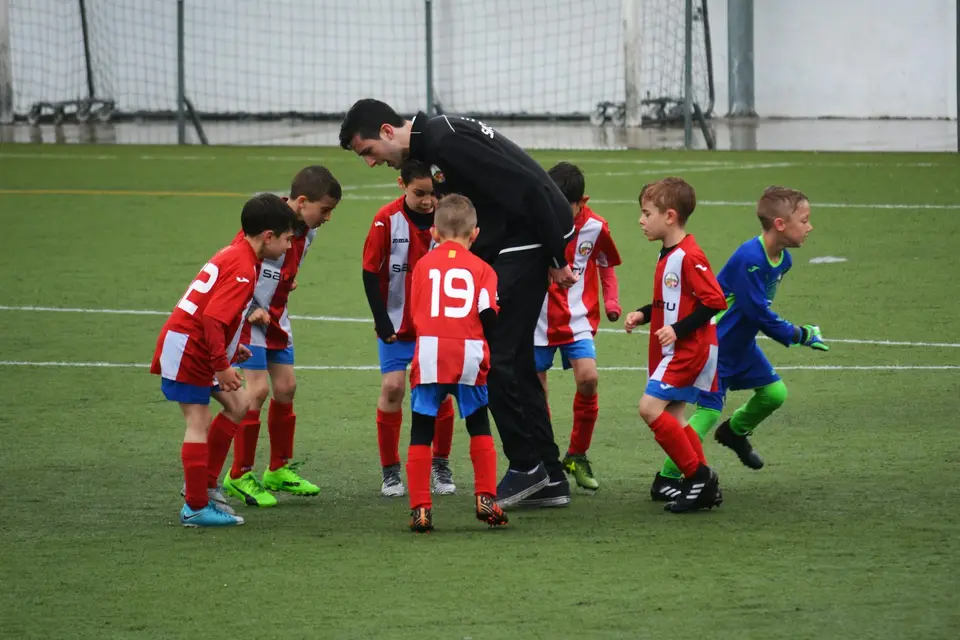 Kinder spielen auf einem Rasenplatz Fußball