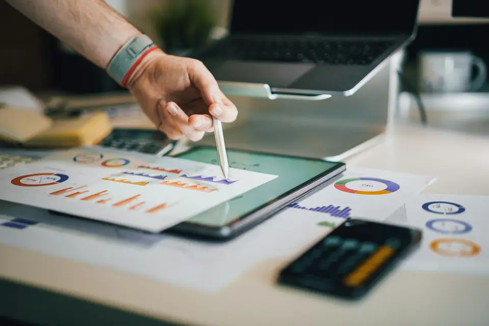 Person using a stylus on a tablet showing charts