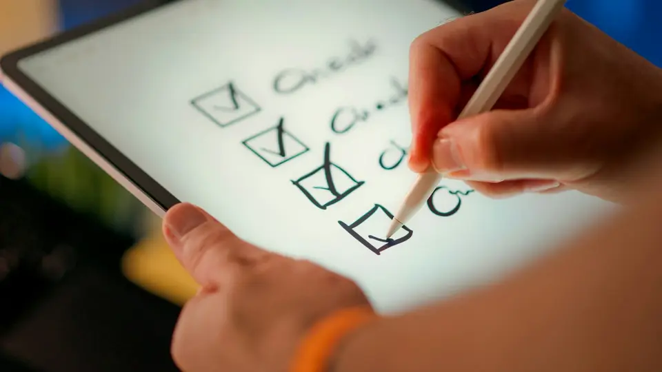 Eine Person hakt auf einem Tablet eine Checkliste ab.