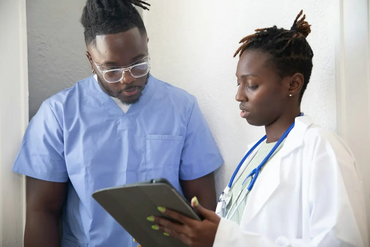 Two healthcare professionals reviewing information on a tablet.