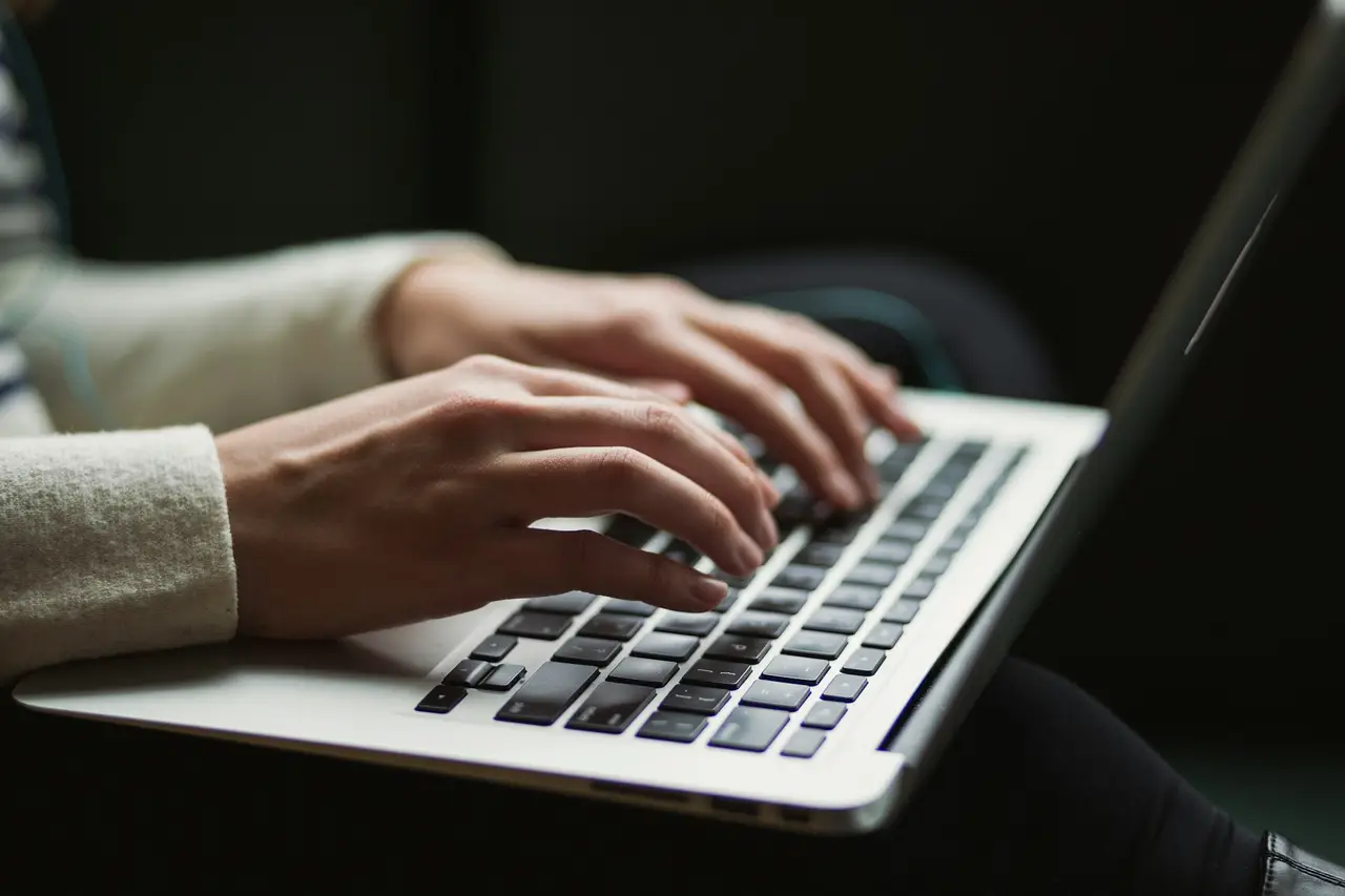 A person typing an update on a laptop.