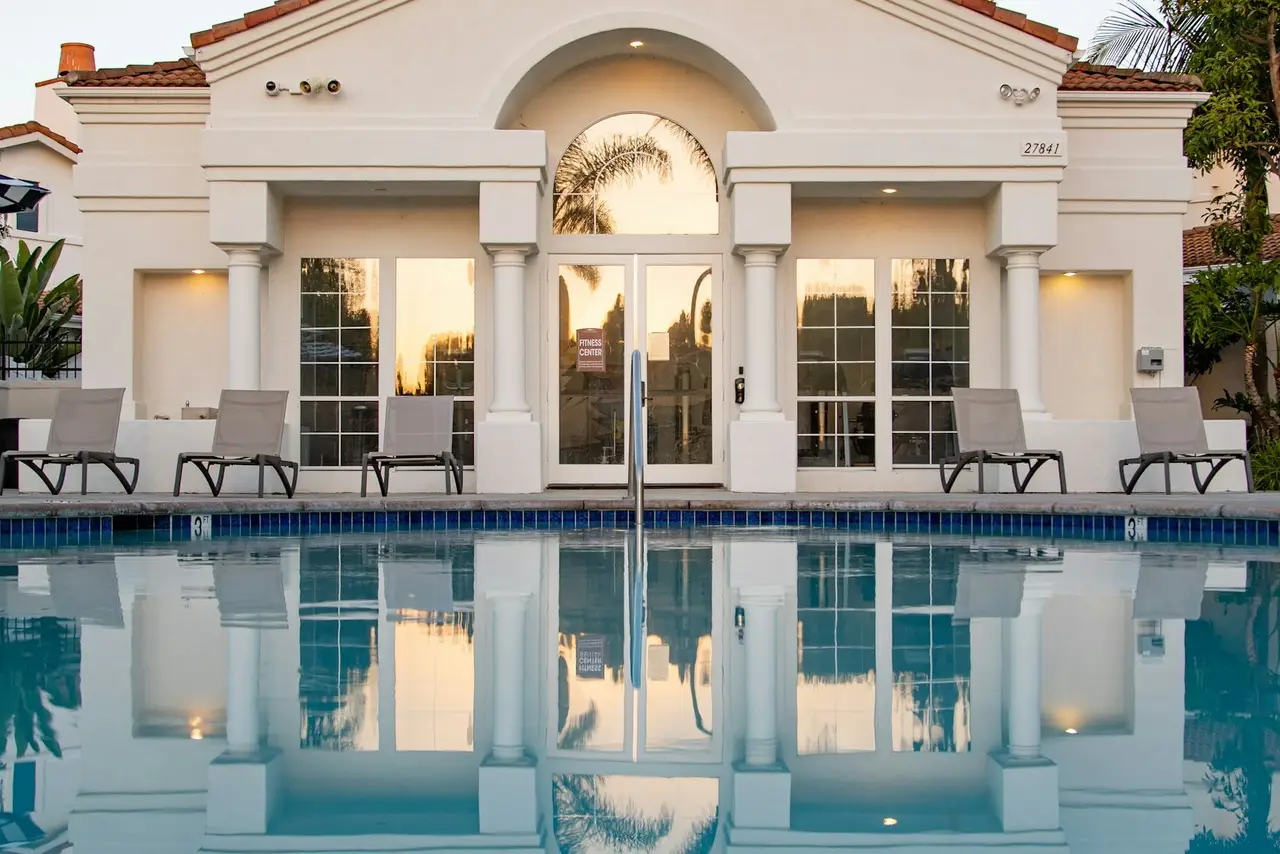 A community clubhouse beside an outdoor swimming pool.