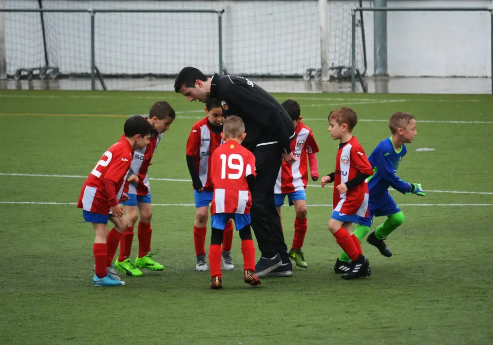 A coach guiding young players during soccer practice.