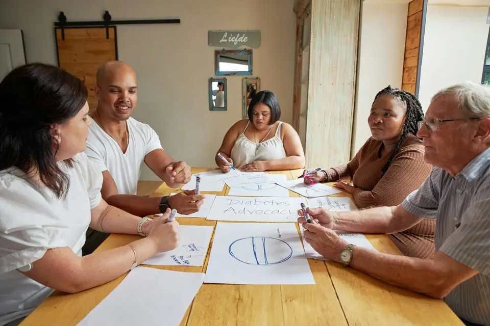 A small group working through notes together around a table.