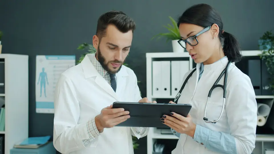 Two doctors reviewing records together on a tablet.