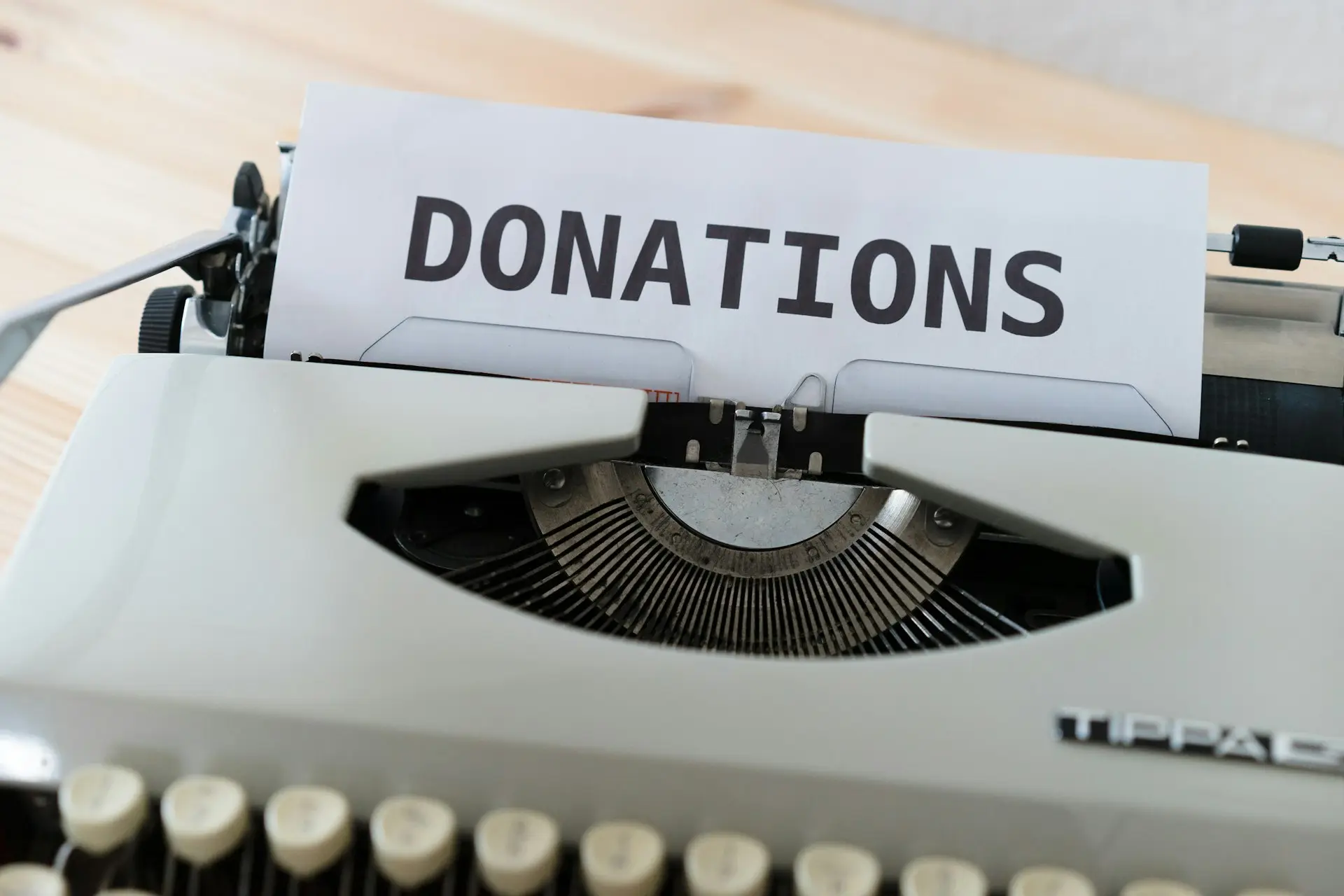 Schreibmaschine mit eingespanntem Blatt, auf dem „Donations“ steht