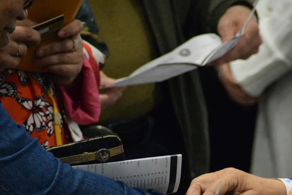 People looking at phones and papers at an event