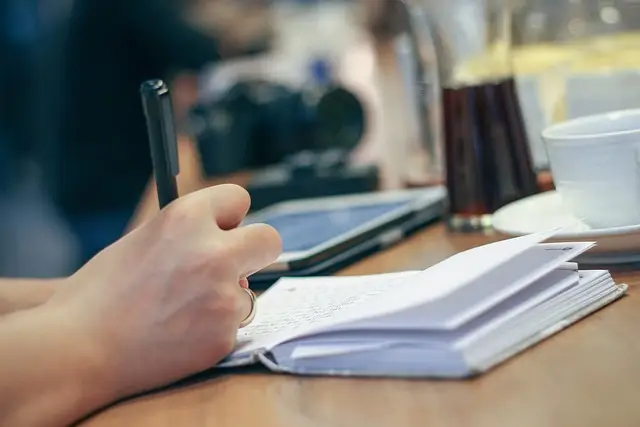 hand hält stift und schreibt in ein buch