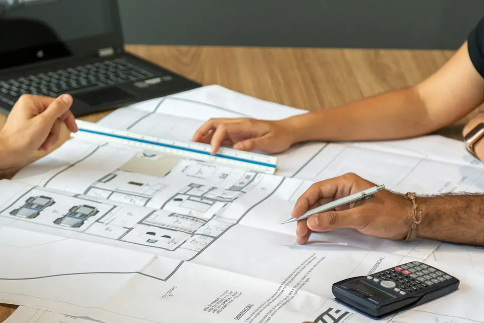 People reviewing architectural plans on a desk