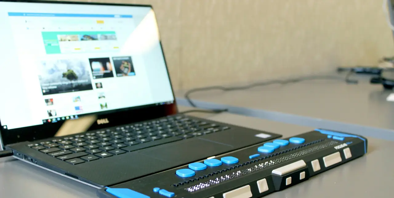 Laptop mit angeschlossener Braillezeile für sehbehinderte oder blinde Nutzer.