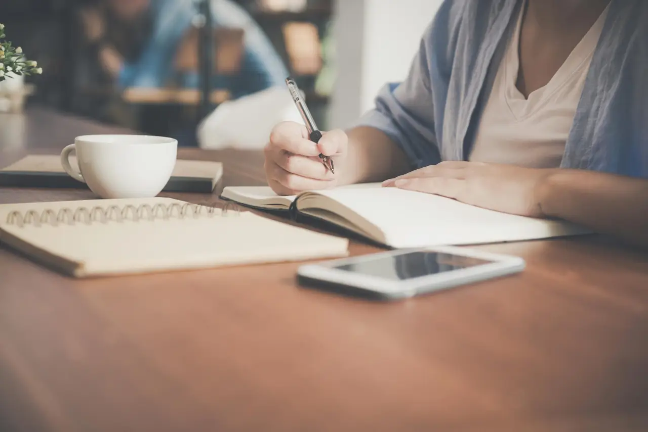 Notizbücher Tasse Hand mit Stift
