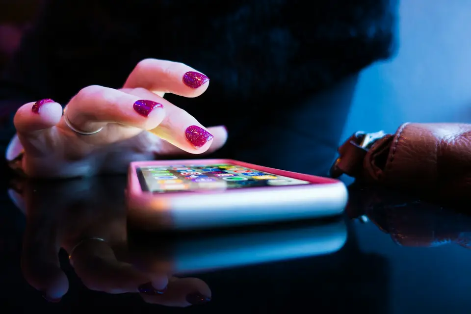Person using a smartphone with a pink case