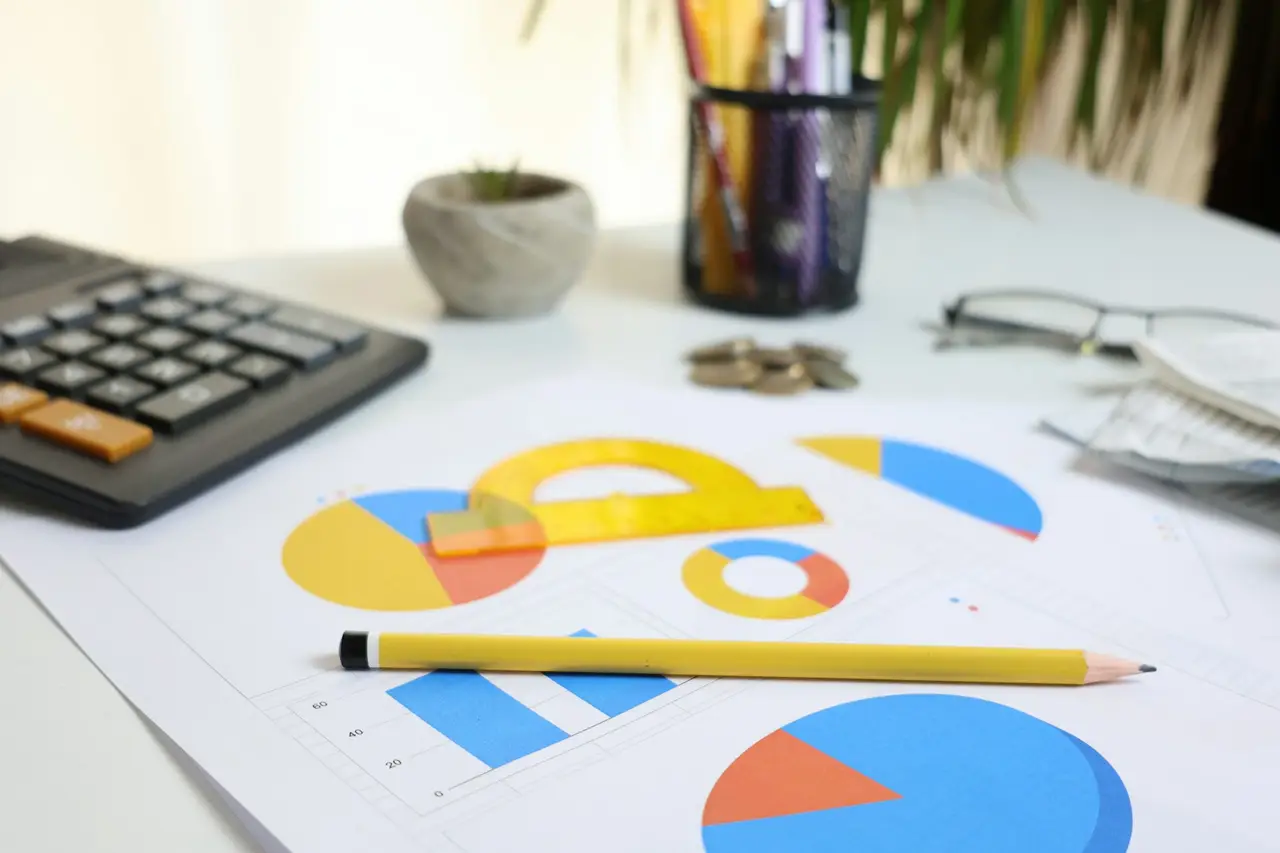 A calculator and financial documents on a desk.