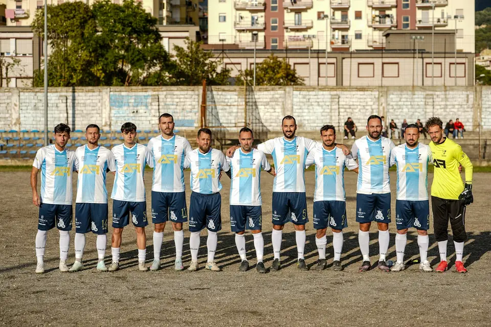 Fußballmannschaft stellt sich auf dem Platz zum Mannschaftsfoto auf