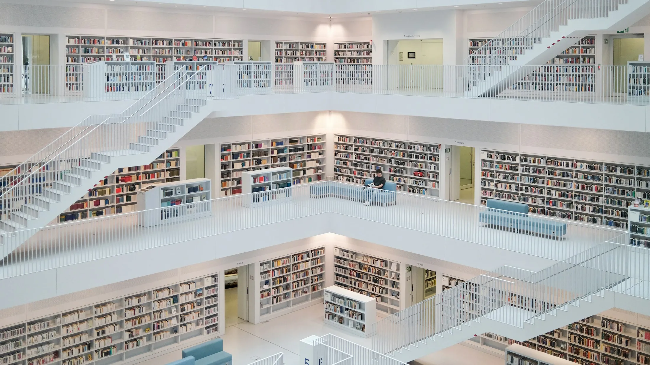 Eine moderne Bibliothek mit hellen Galerien und Bücherregalen.