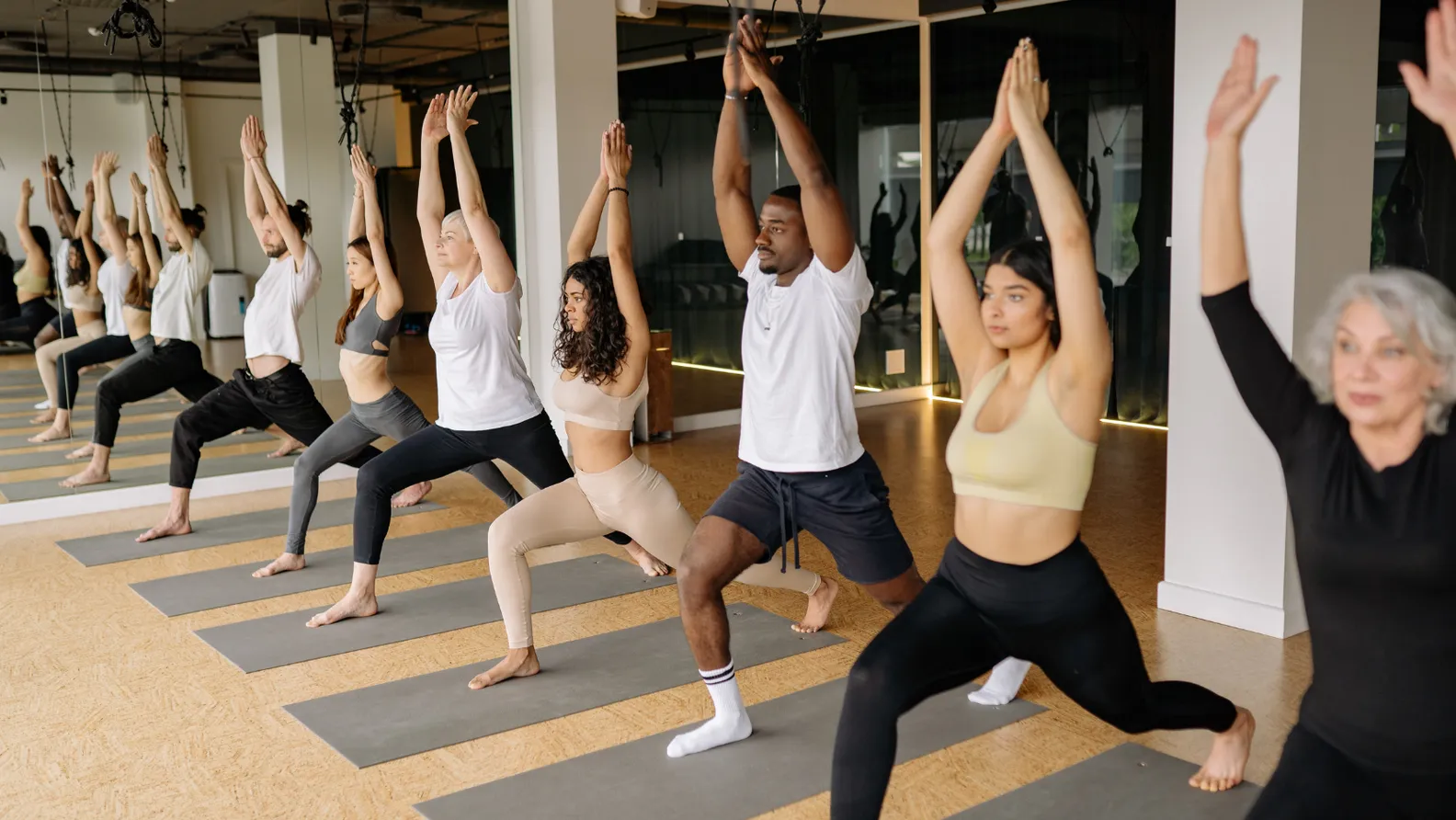 Eine Yogagruppe übt gemeinsam in einem hellen Studio.