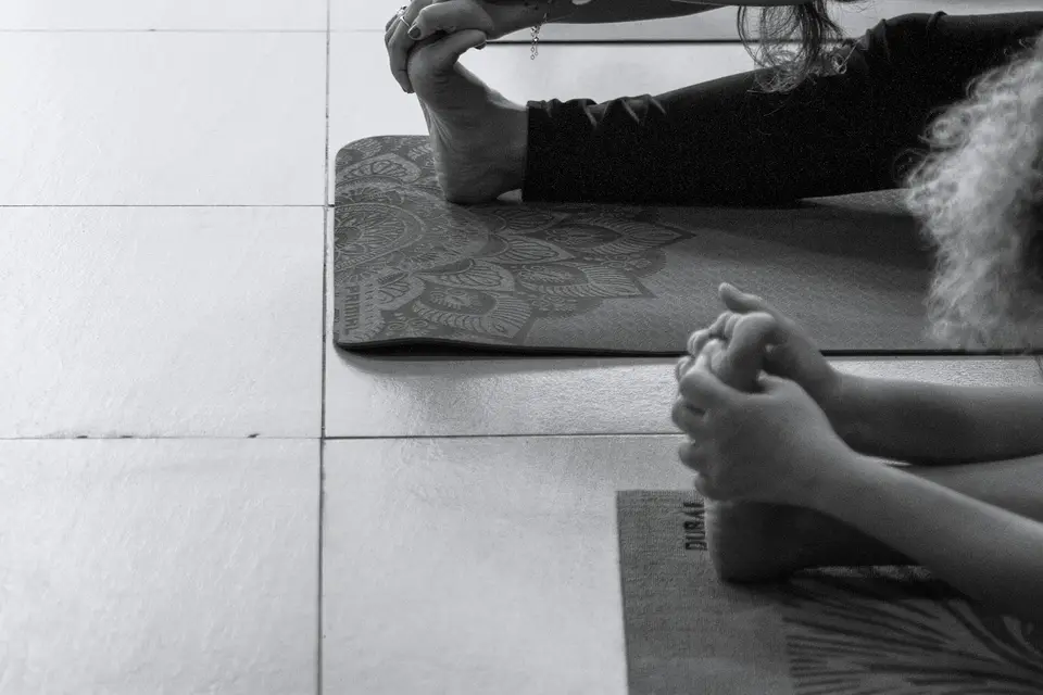 Teilnehmende dehnen sich in einem Kurs auf Yogamatten