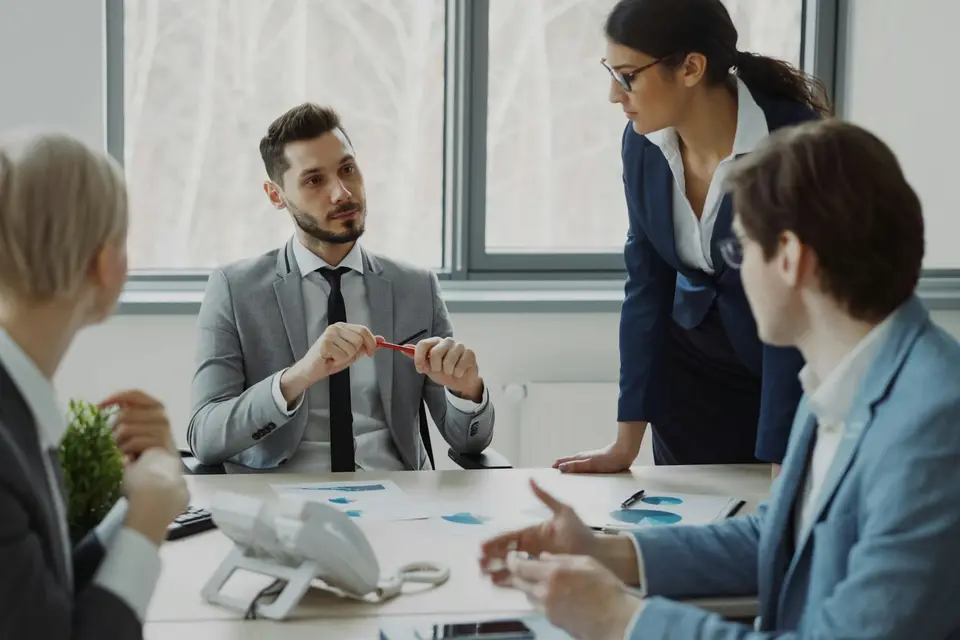 Fünf Personen besprechen an einem Konferenztisch gemeinsam Unterlagen