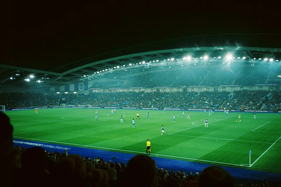 Fußballspiel in einem Stadion bei Nacht unter Flutlicht