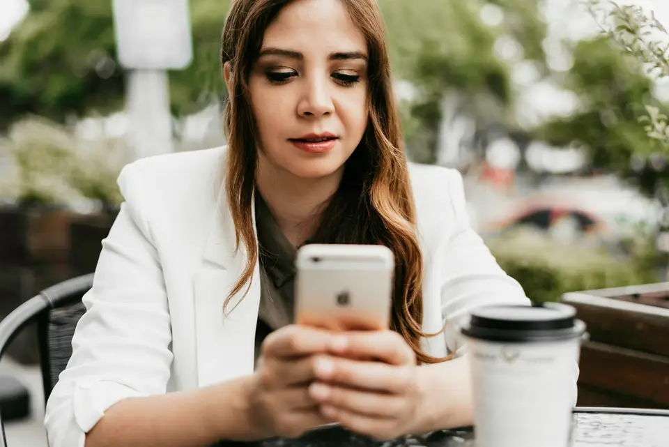 Eine Frau bucht im Café mit dem Smartphone.