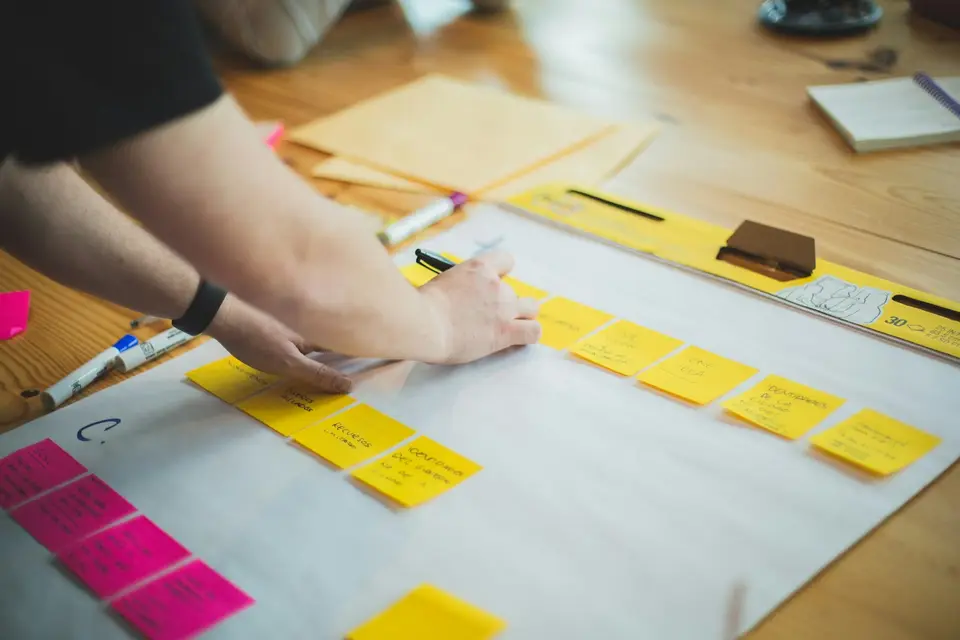 Person schreibt auf ein weißes Blatt Papier