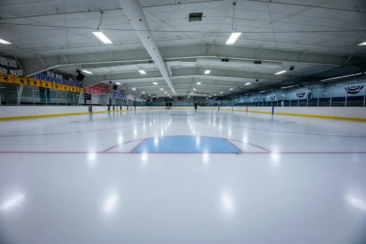 Eine leere Eishockeyhalle mit frisch aufbereiteter Eisfläche.