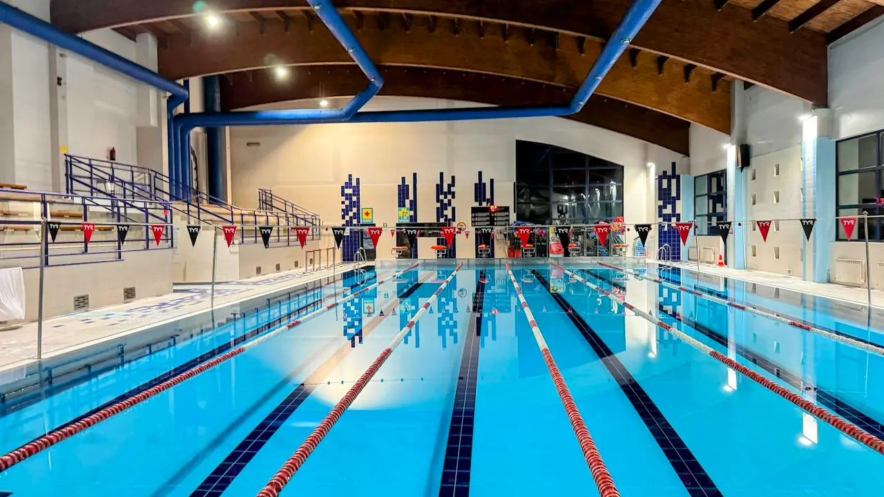 Eine leere Schwimmhalle mit mehreren Bahnen.