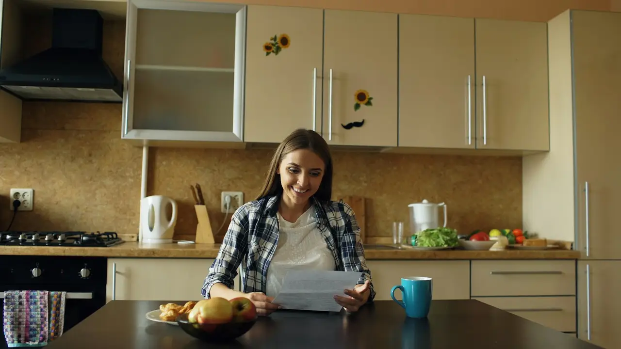 Eine Frau arbeitet in der Küche an ihren Unterlagen.