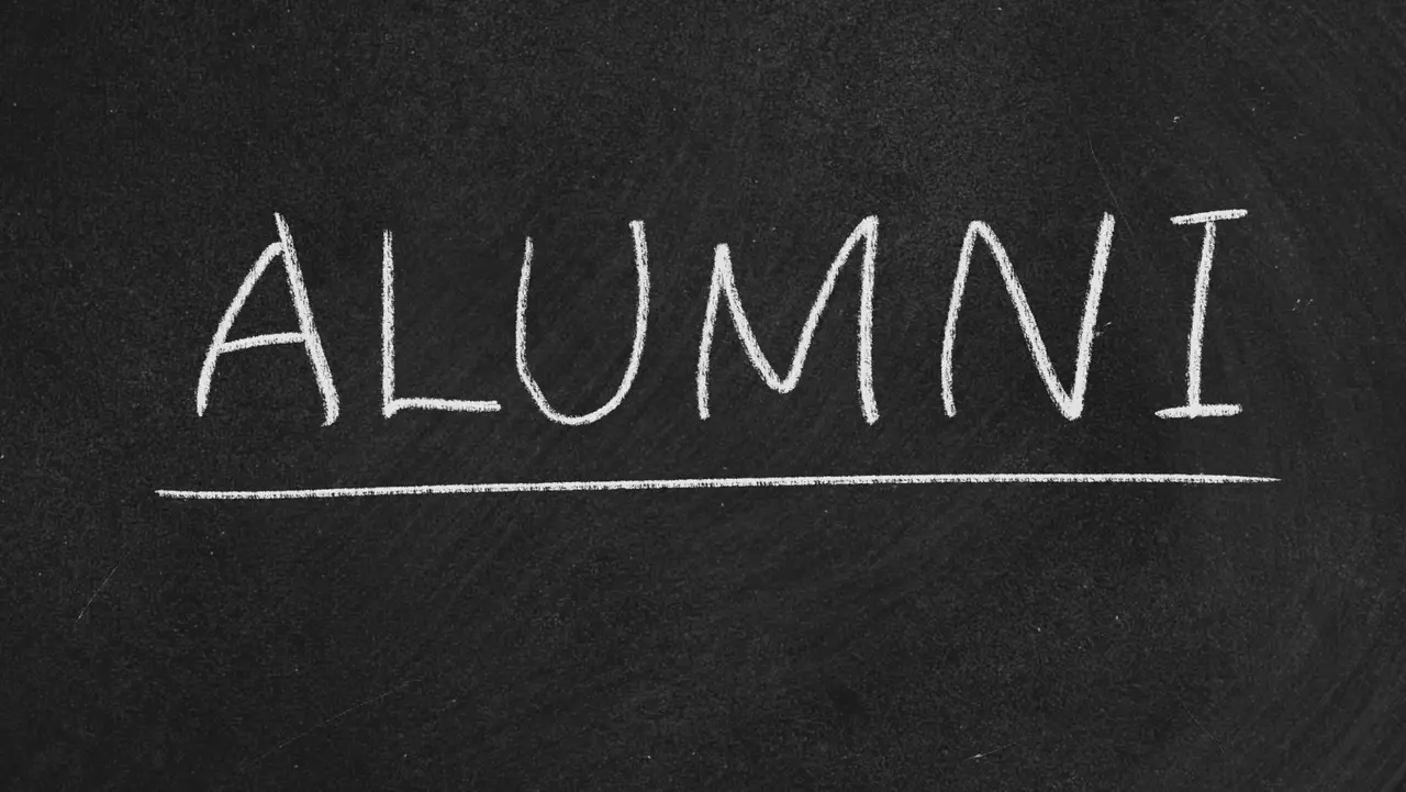 Schwarze Tafel mit weißer Alumni Schrift