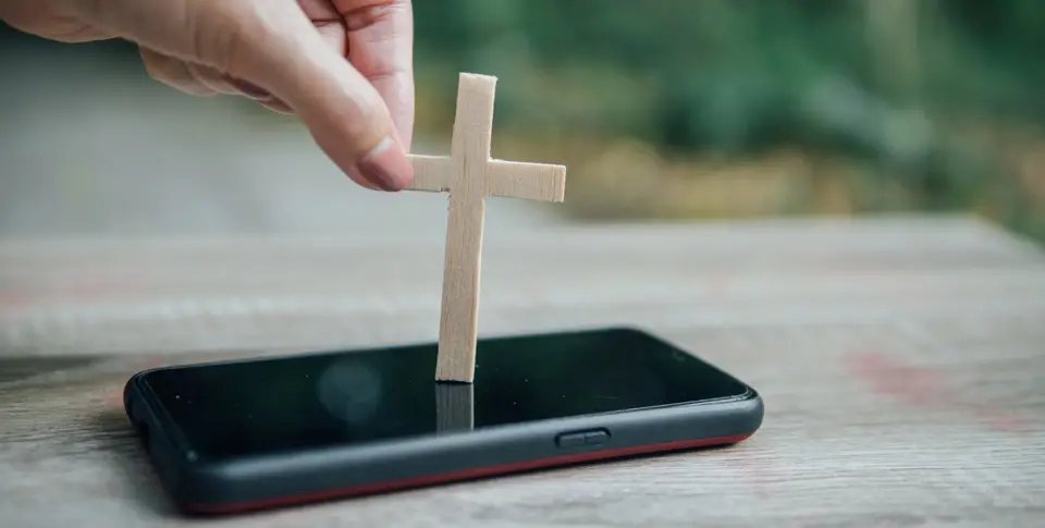 Kreuz aus Holz auf Smartphone