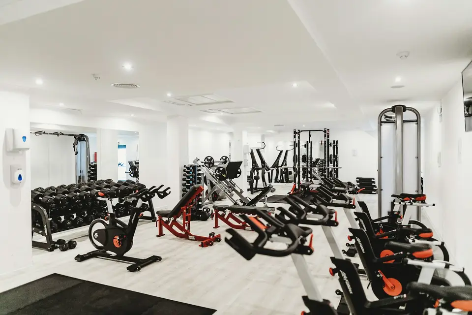 Fitnessgeräte stehen in einem hellen Studioraum.