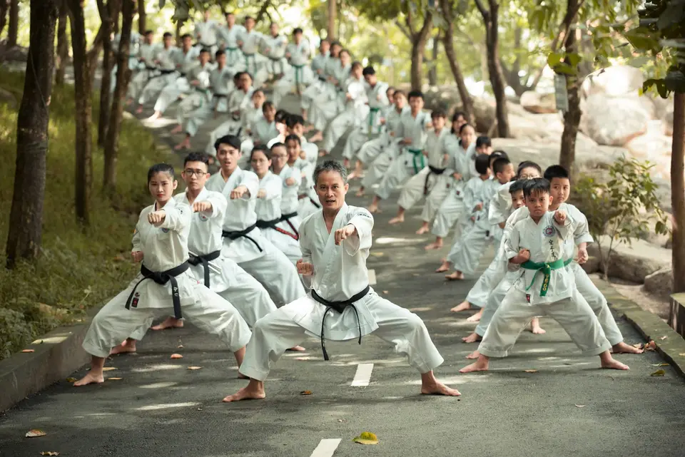 Eine große Gruppe trainiert in weißen Anzügen gemeinsam Karate.
