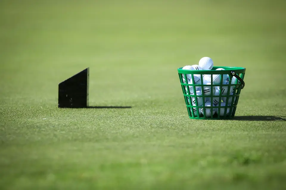 Ein Korb mit Golfbällen steht auf der Driving Range.