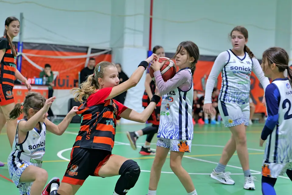 Nachwuchsspielerinnen spielen in einer Halle Handball.