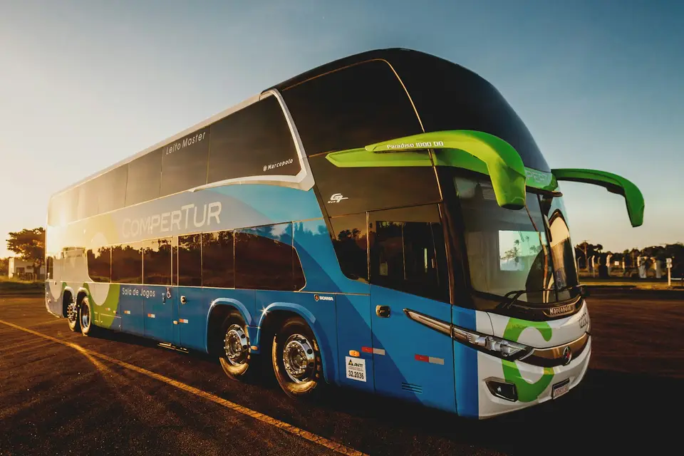 Ein Reisebus steht bei Sonnenuntergang auf einem Parkplatz.