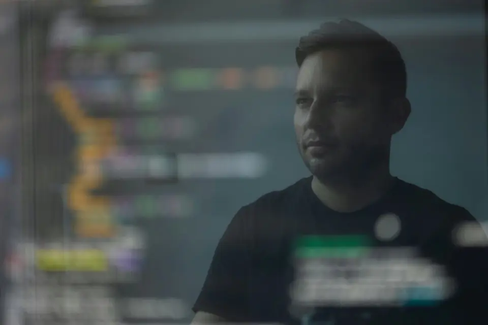 Ein Mitarbeiter arbeitet am Computer vor mehreren Bildschirmen.