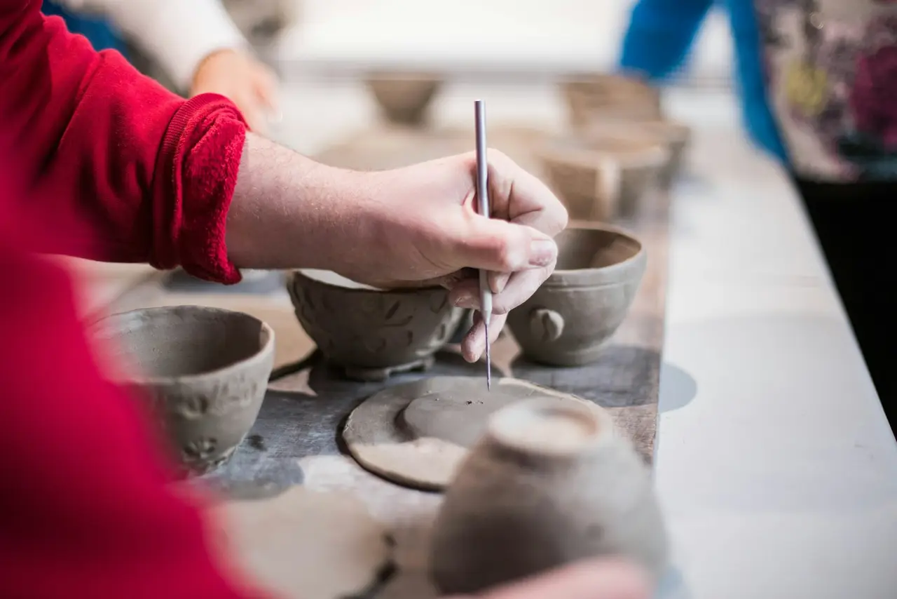 Participants shaping clay pieces during a pottery class.